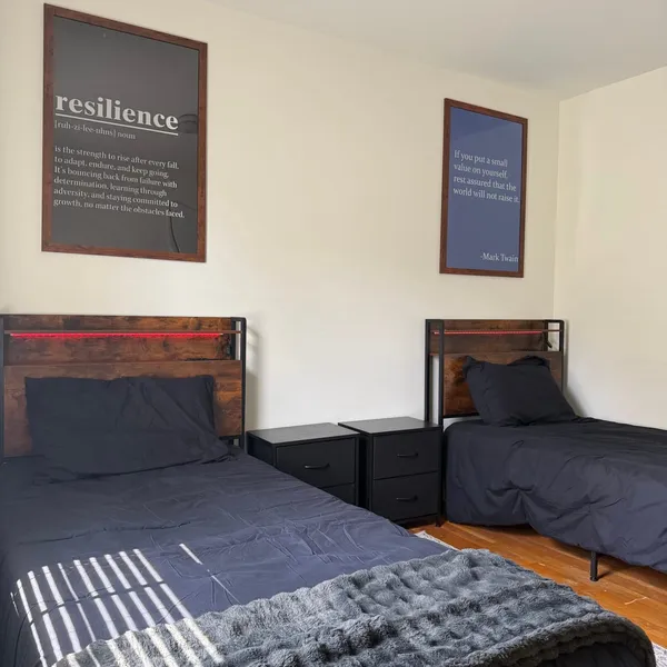 Bedroom at Sutter House with two beds and motivational wall art