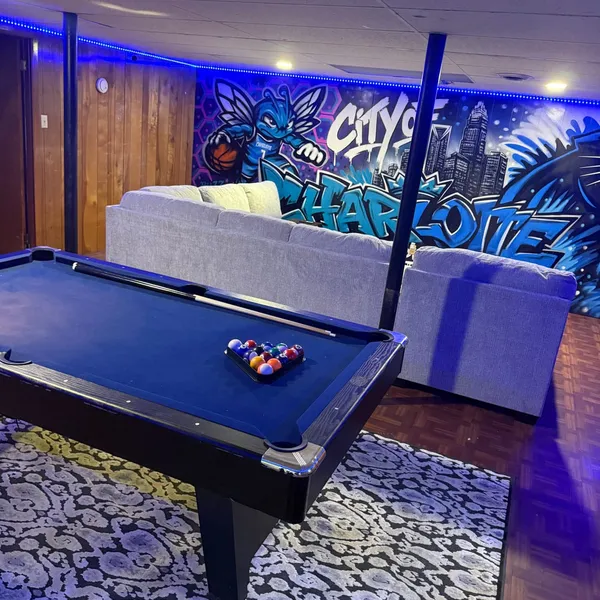 Basement recreation room at Sutter House with a pool table and lounge seating